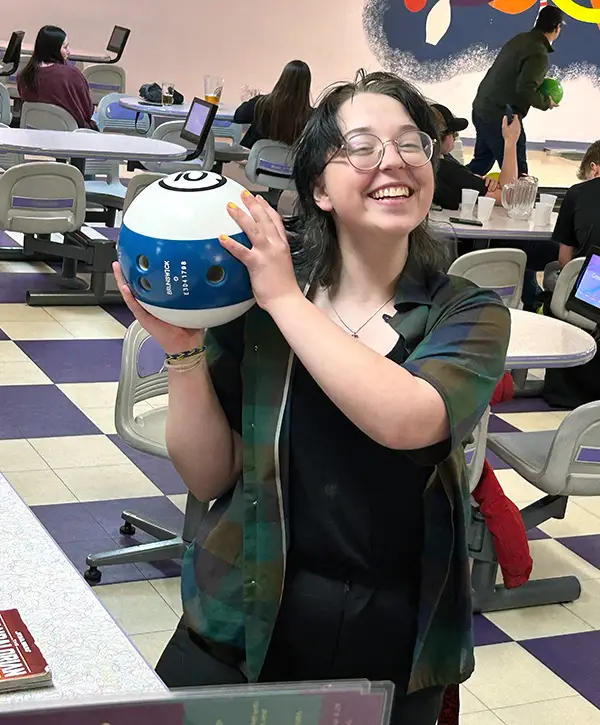 Youth smiling and holding bowling ball